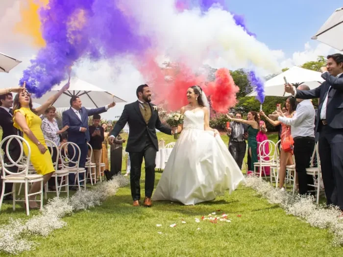 A joyful wedding celebration with colorful smoke in León, México.
